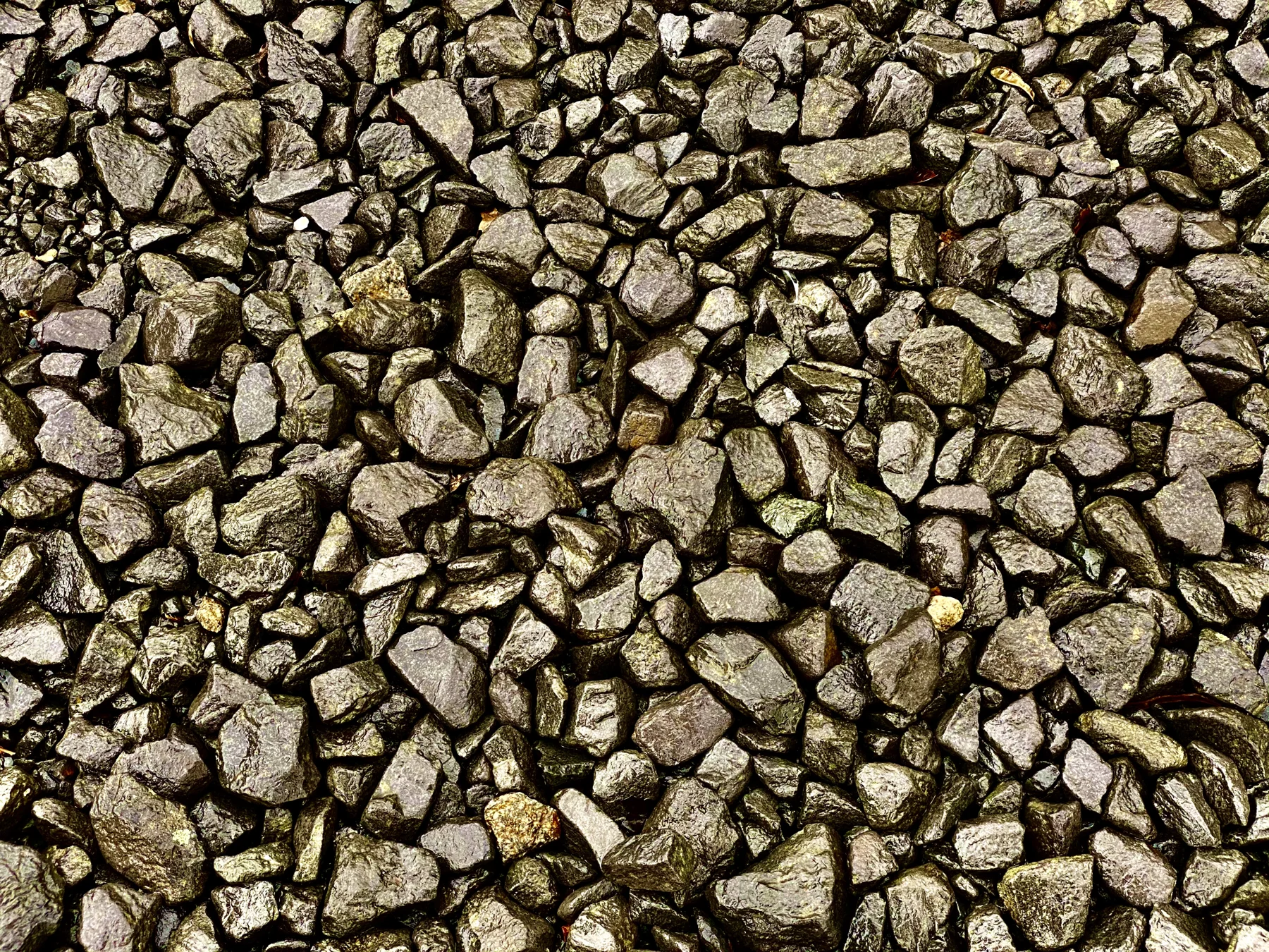 A close-up fills the frame with angular railway ballast stones in grey and brown tones.