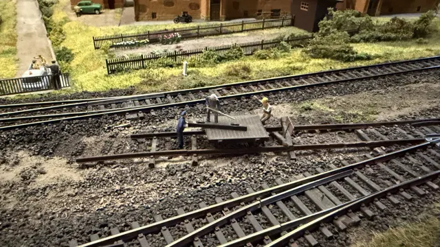 A close view of model track points, sleepers and buffer stops in a railway yard.