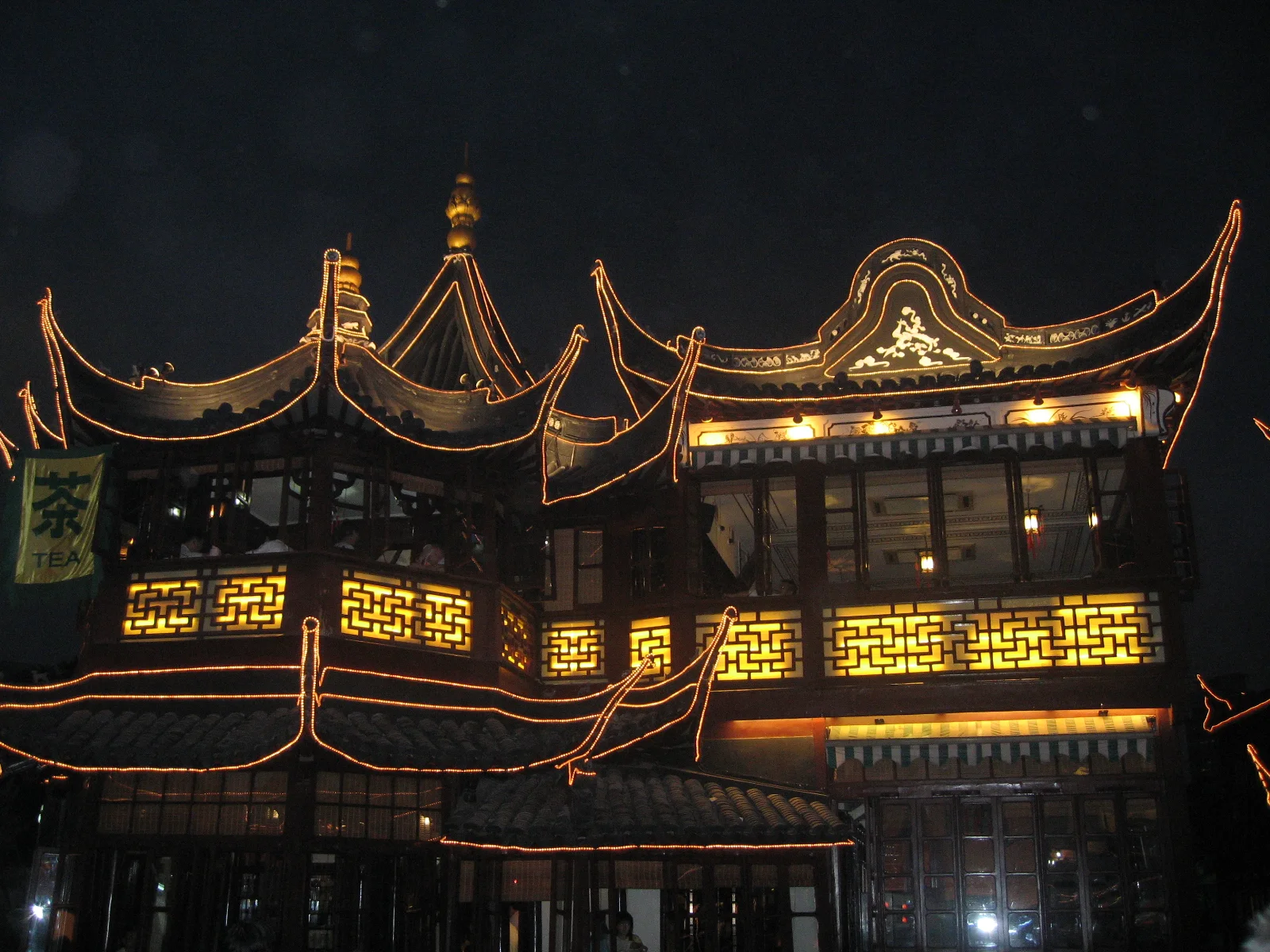 Curved rooflines and patterned windows glow gold against a dark evening sky.