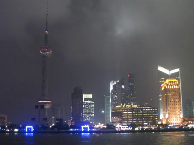 An illuminated skyline stretches beside a tall spherical-section tower above the dark river.