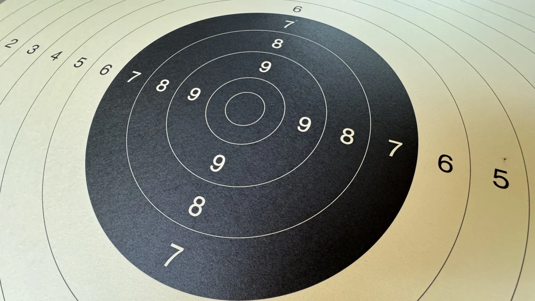 Numbered circles spread across a cream paper target, with the black centre seen from an oblique angle.