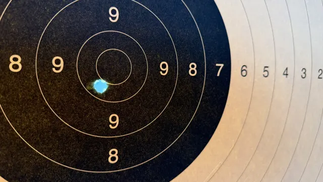 A small blue-white opening interrupts the dark paper just below and left of the central circle, with scoring numbers extending to the right.
