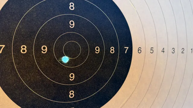 A close view of a hole overlapping an inner scoring ring, with the black target centre and pale outer rings around it.