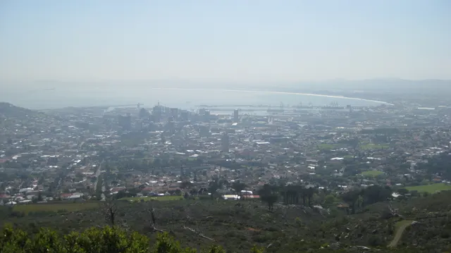Dense development stretches toward distant water beneath a hazy sky.