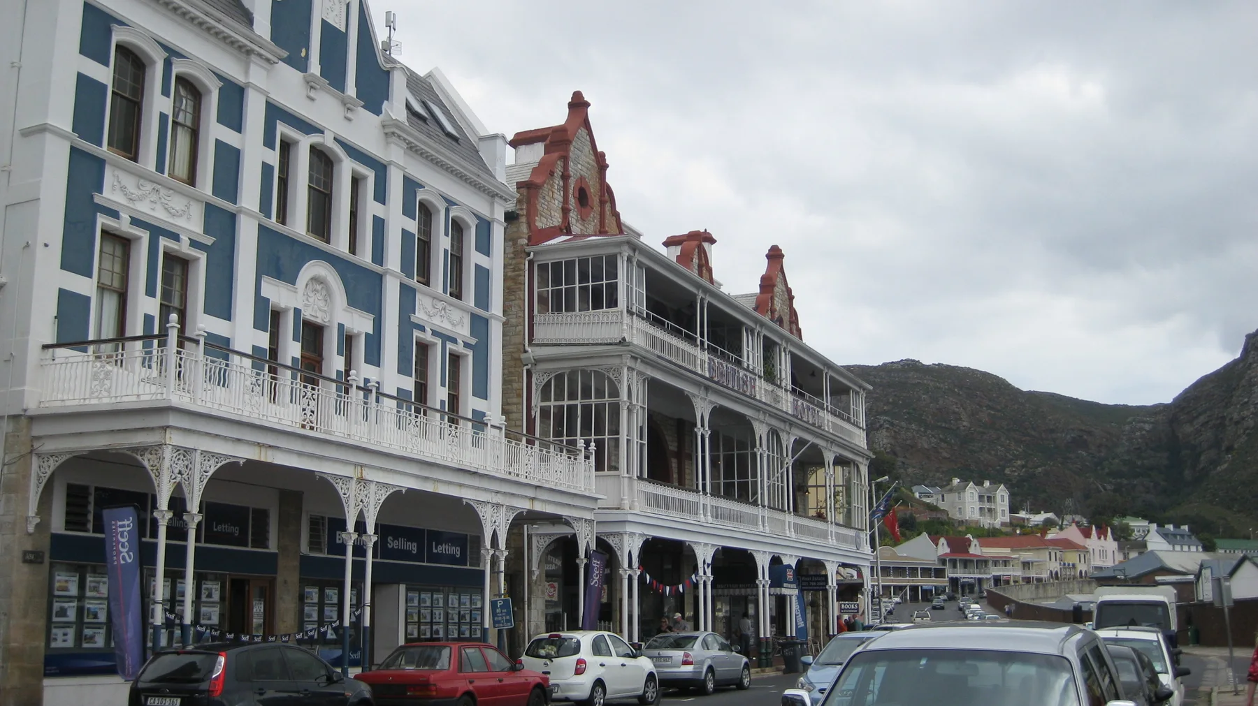 Ornate multistory facades and balconies line a busy town street.