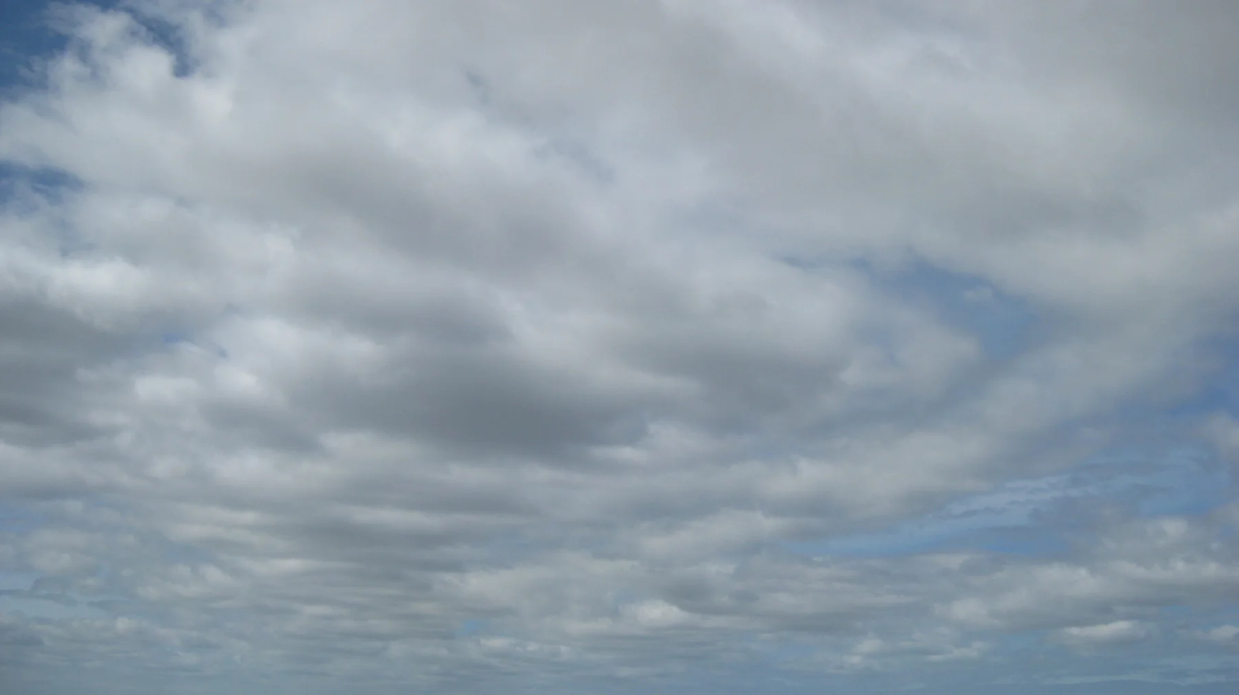 Overlapping gray clouds cover most of the sky.