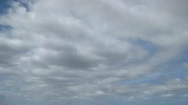 Overlapping gray clouds cover most of the sky.