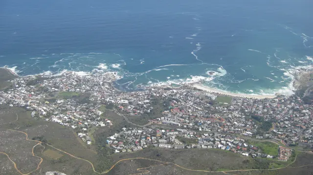 Dense coastal neighborhoods sit beside blue water and white-edged coves.