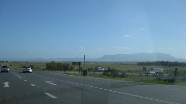 Road arrows and vehicles mark a junction across open countryside.