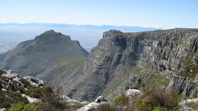 A high cliff and pointed peak overlook a deep valley.