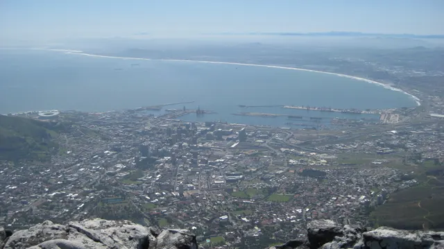 A city and harbor spread toward a broad curved bay.