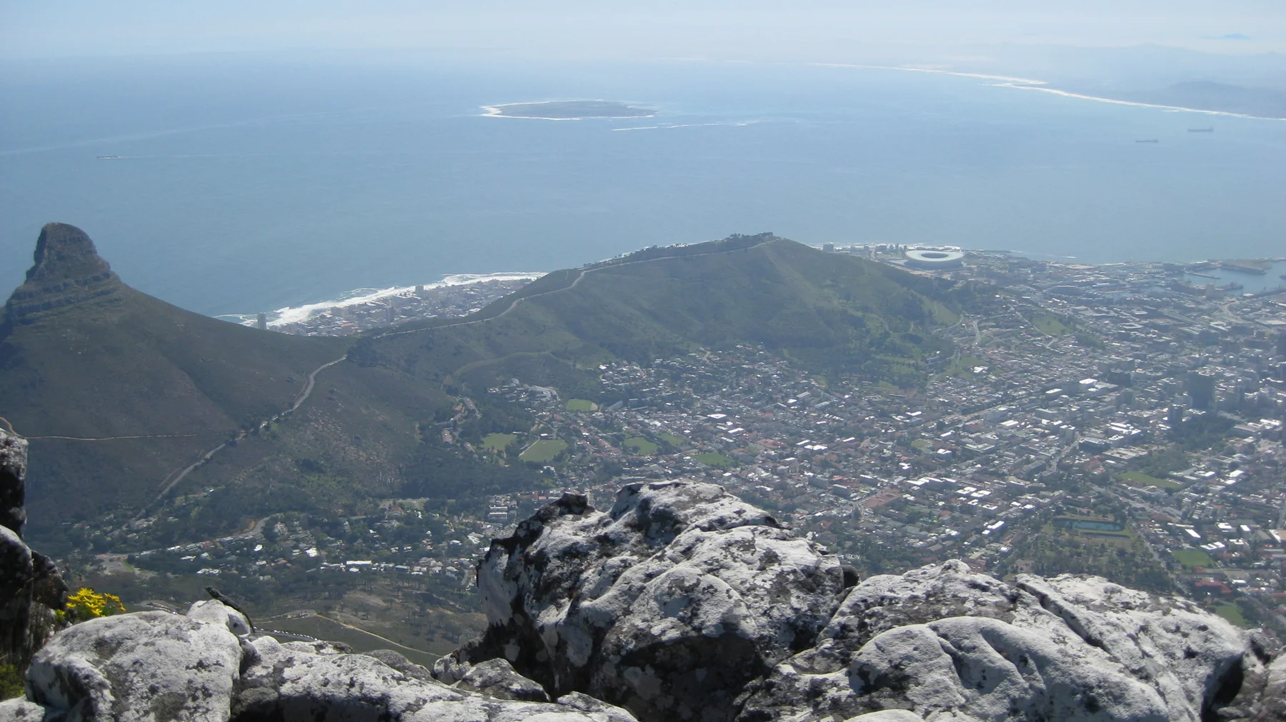 Pointed hills rise above the city beside the blue ocean.
