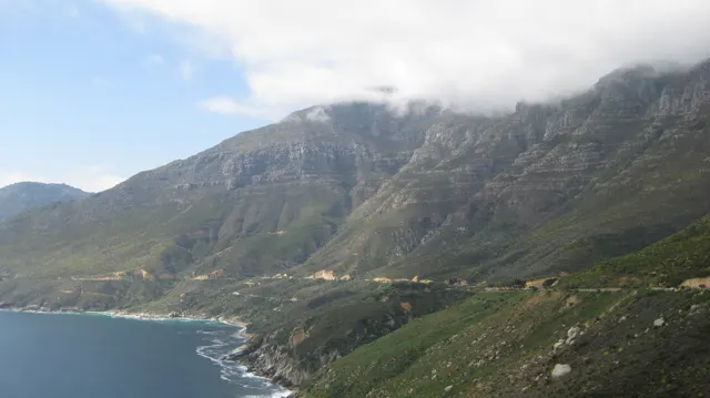 White cloud rests on a long steep ridge above the shoreline.