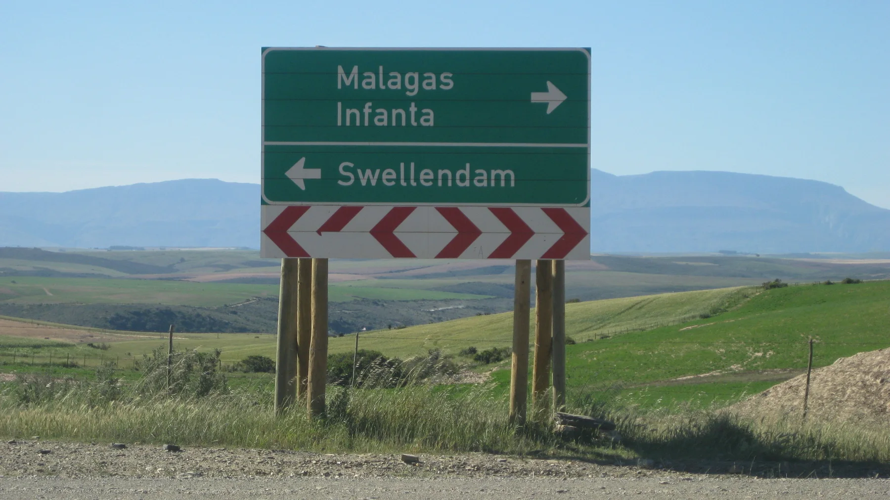 A green sign points toward Malagas, Infanta and Swellendam beside fields.