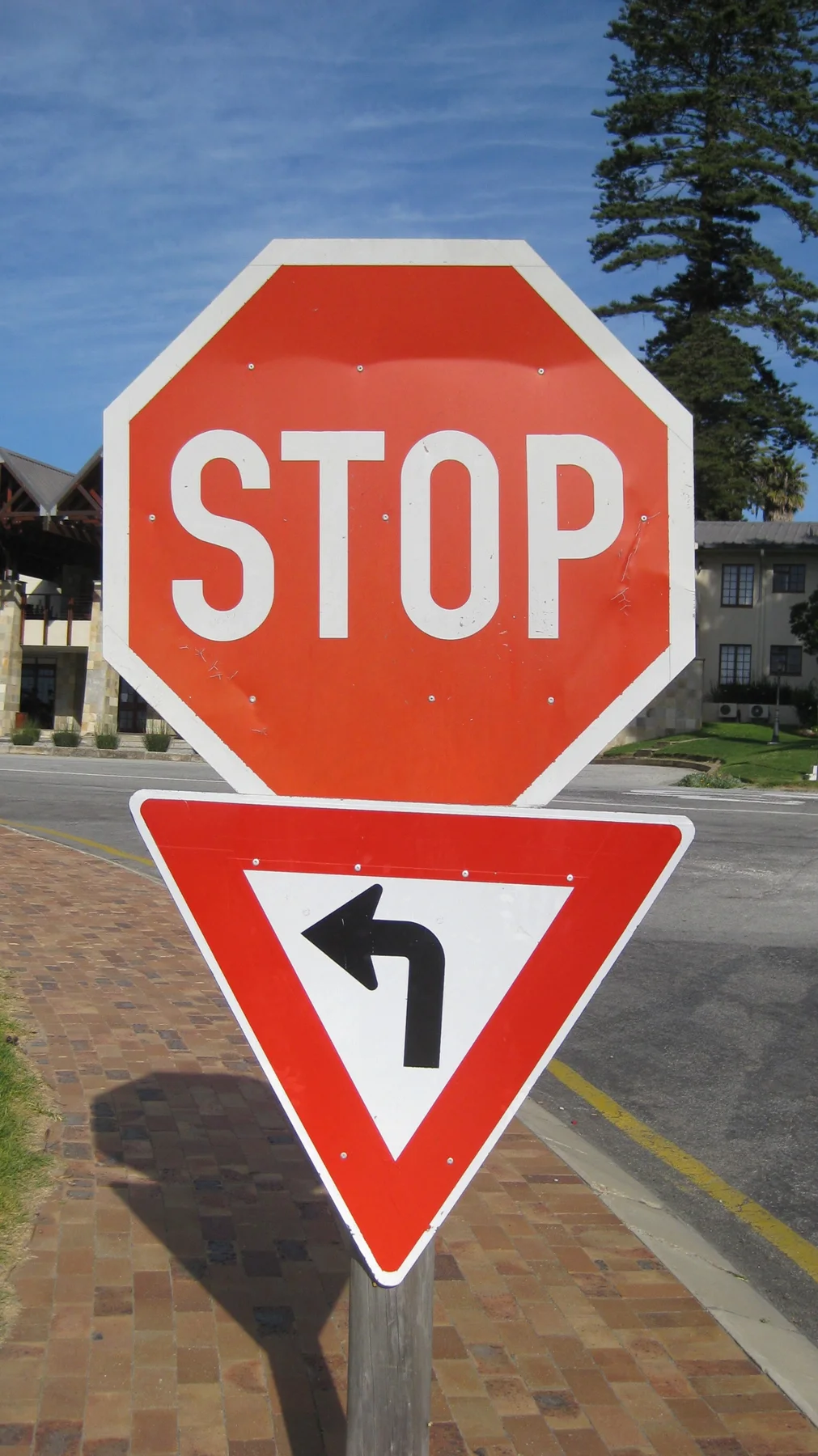 A red stop sign stands above a left-turn direction symbol.