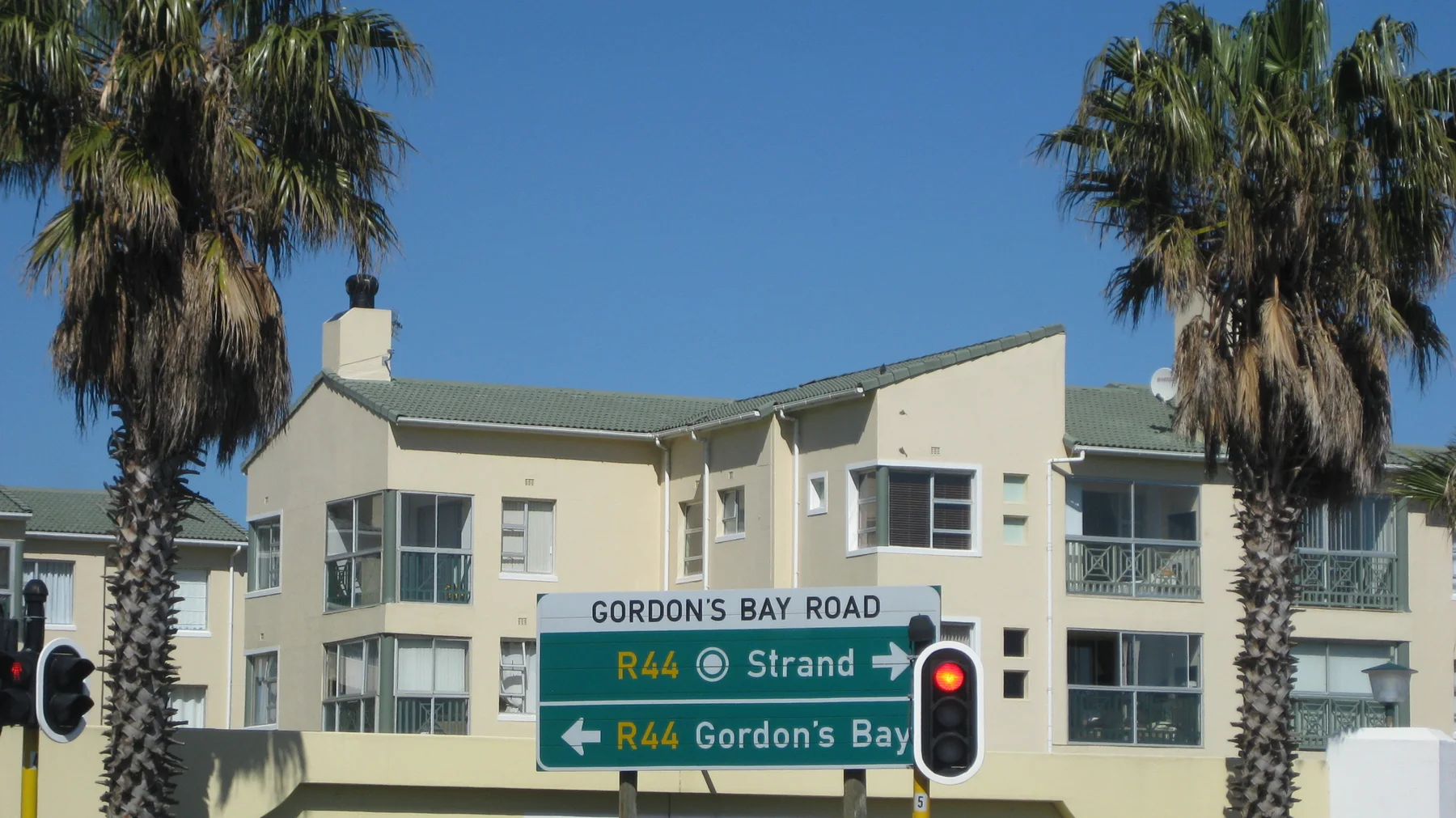 Road signs near traffic lights indicate Strand and Gordon's Bay.