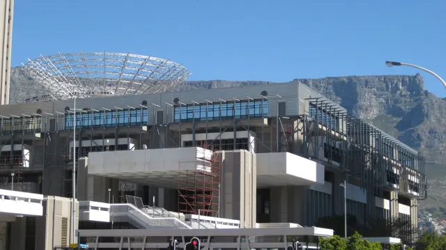 An open metal framework tops a modern city building.