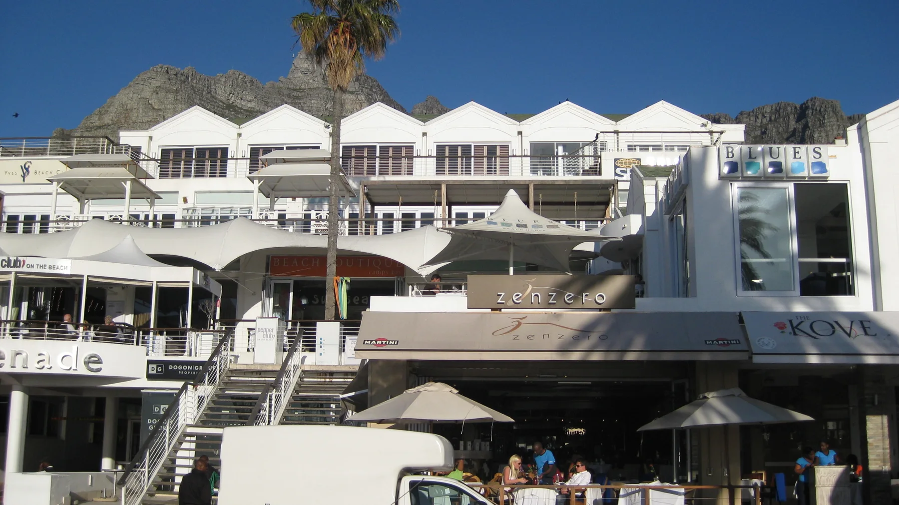 Balconies and terraces divide a white commercial facade.