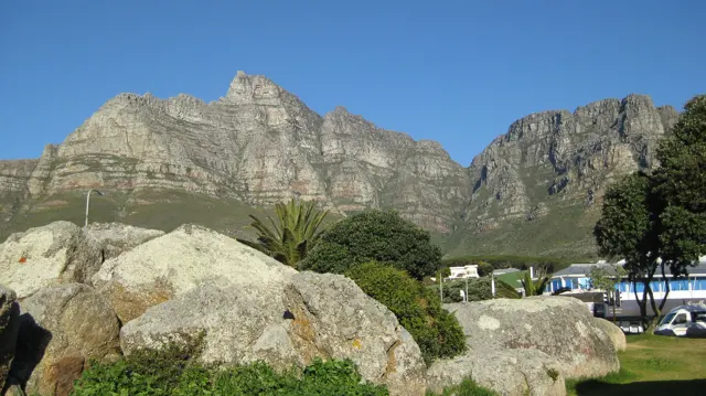 Large foreground boulders frame a rugged mountain backdrop.