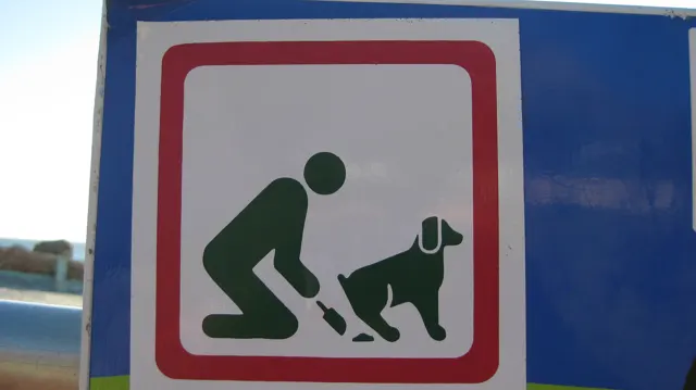 A pictogram sign asks dog owners to clean up after their pets.