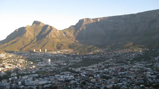 Sunlit cliffs rise above shaded neighborhoods.