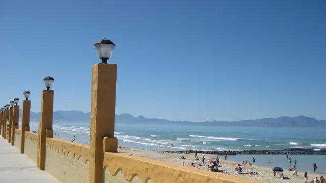 Lamps top ochre posts along a busy beach promenade.