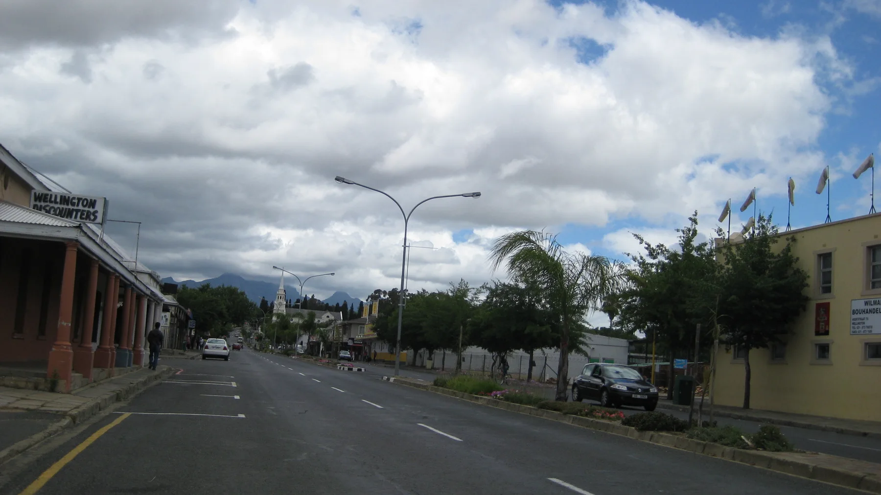Flags line a building beside a quiet town street.