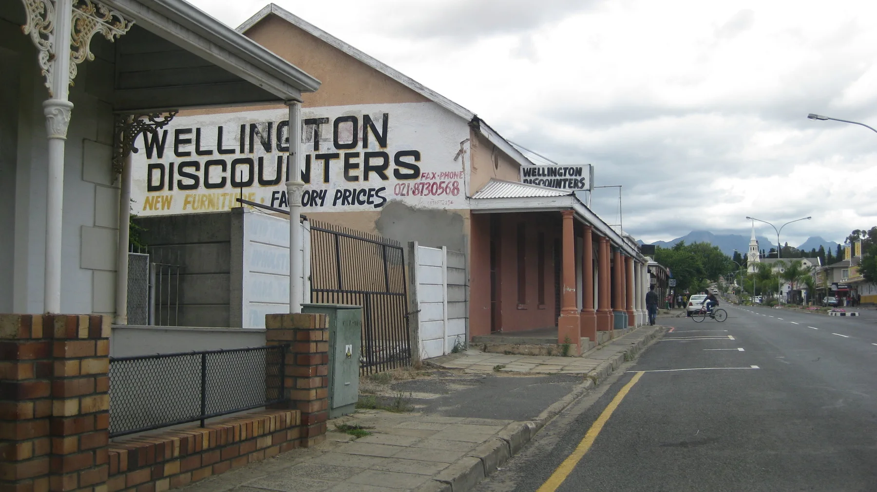 A Wellington Discounters sign hangs from a roadside veranda.