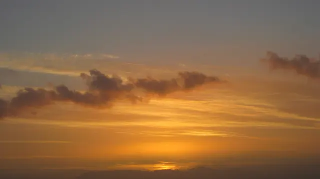 Dark clouds hover above the last warm glow near the horizon.