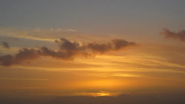 A thin bright strip remains below a softly lit cloud layer.