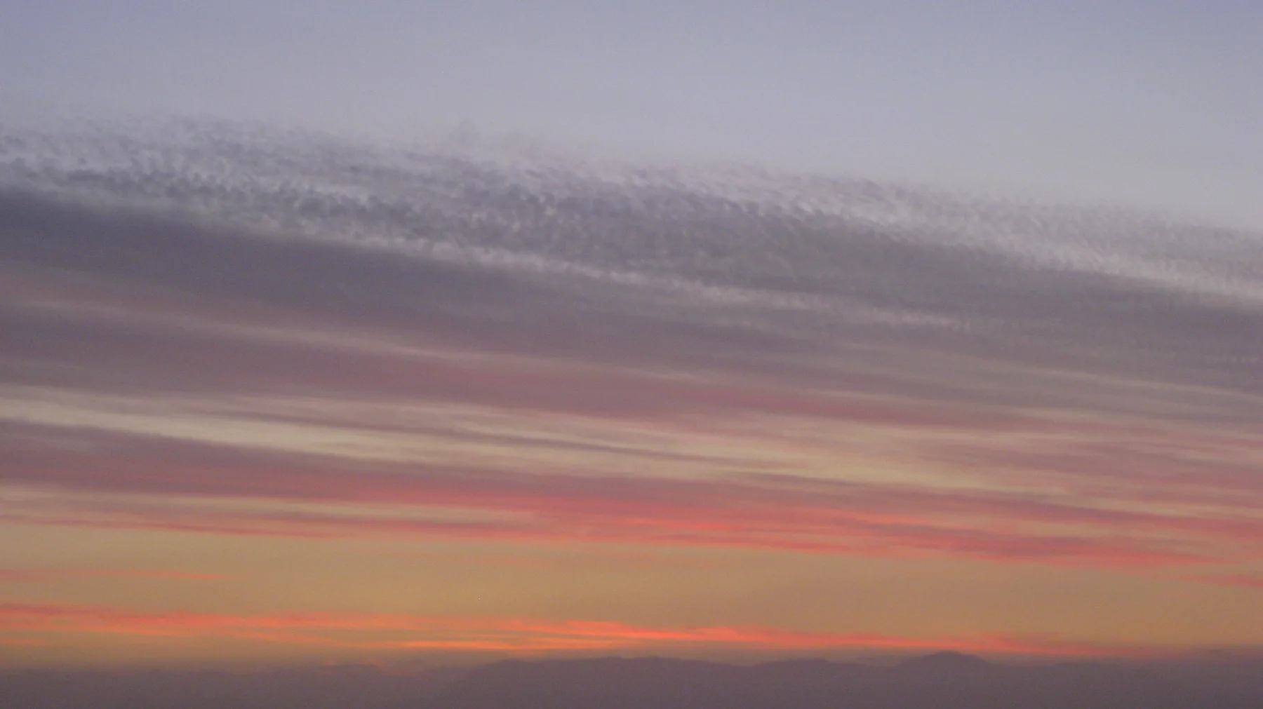 Pink and purple cloud bands stretch across a dusk sky.