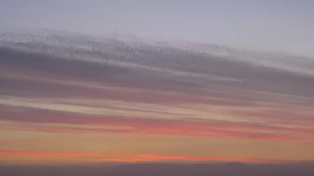 Pink and purple cloud bands stretch across a dusk sky.