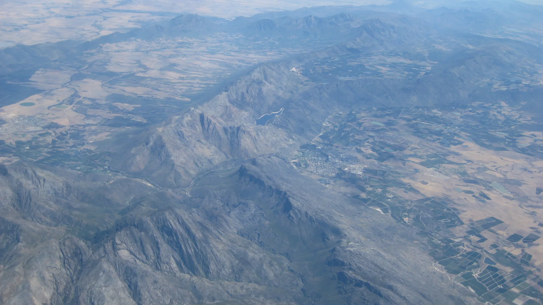 Long folded mountain ridges divide fields far below.