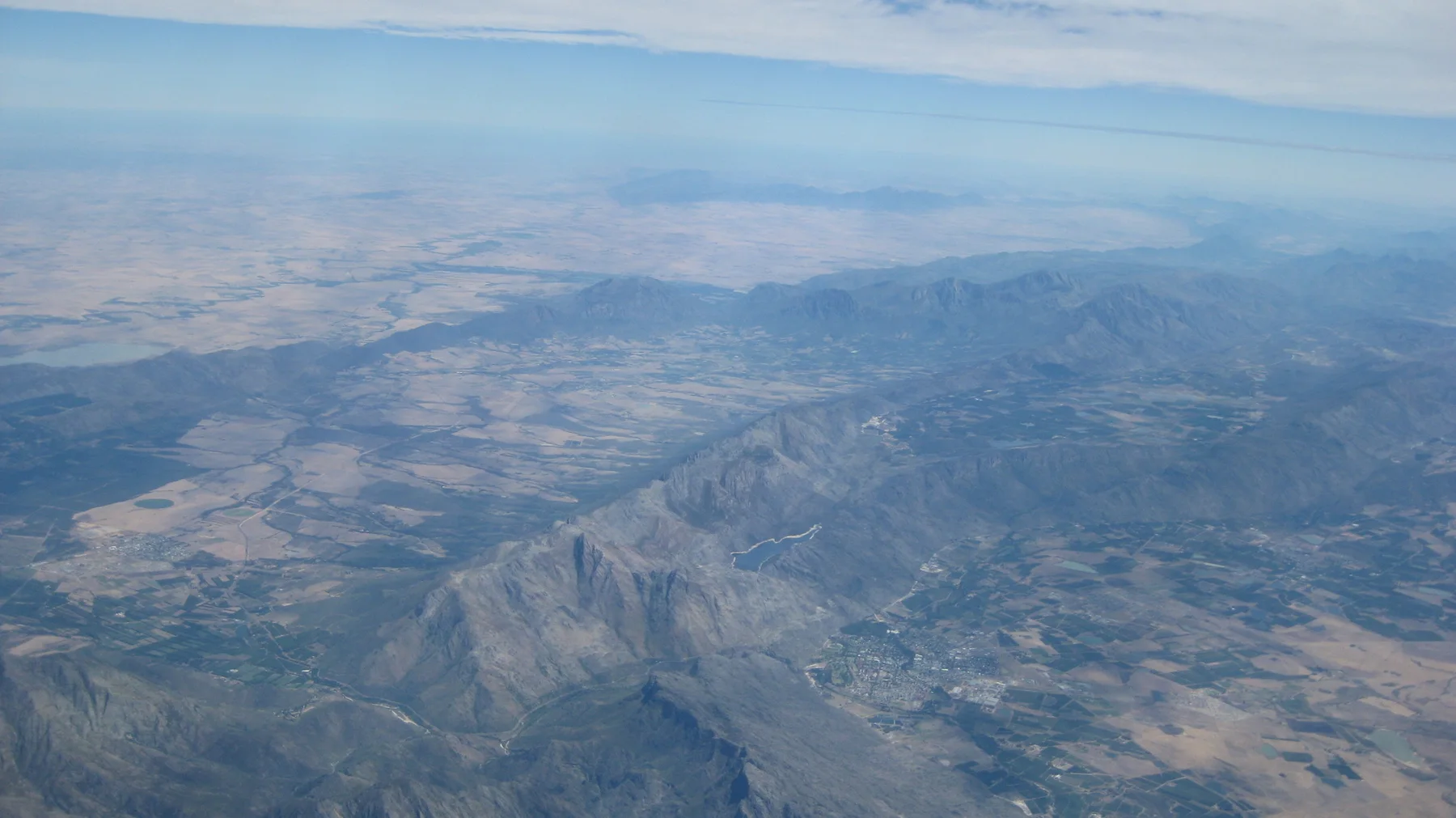 Fields and mountains form a broad aerial patchwork.