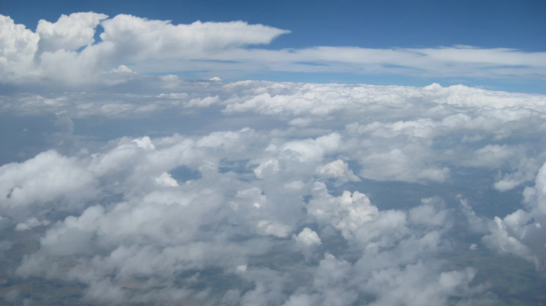 A broad white cloudscape stretches toward the blue horizon.