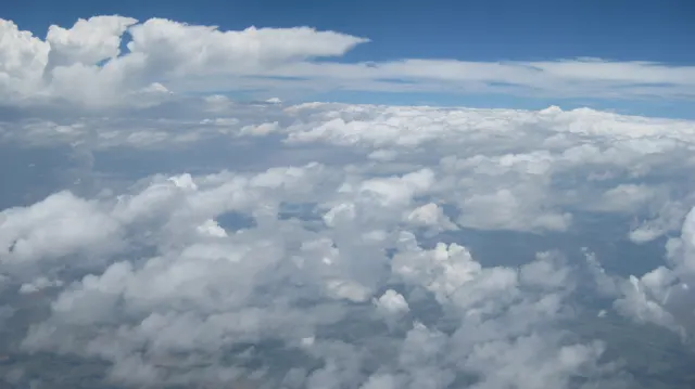 A broad white cloudscape stretches toward the blue horizon.