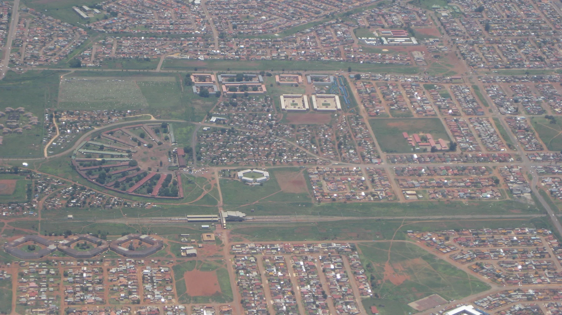 Straight roads and curved street patterns divide neighborhoods seen from above.