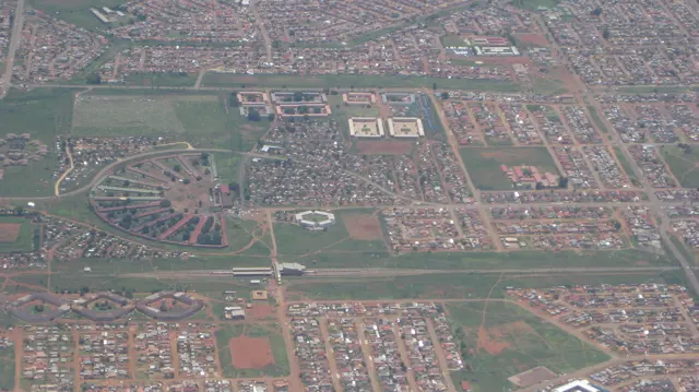 Straight roads and curved street patterns divide neighborhoods seen from above.
