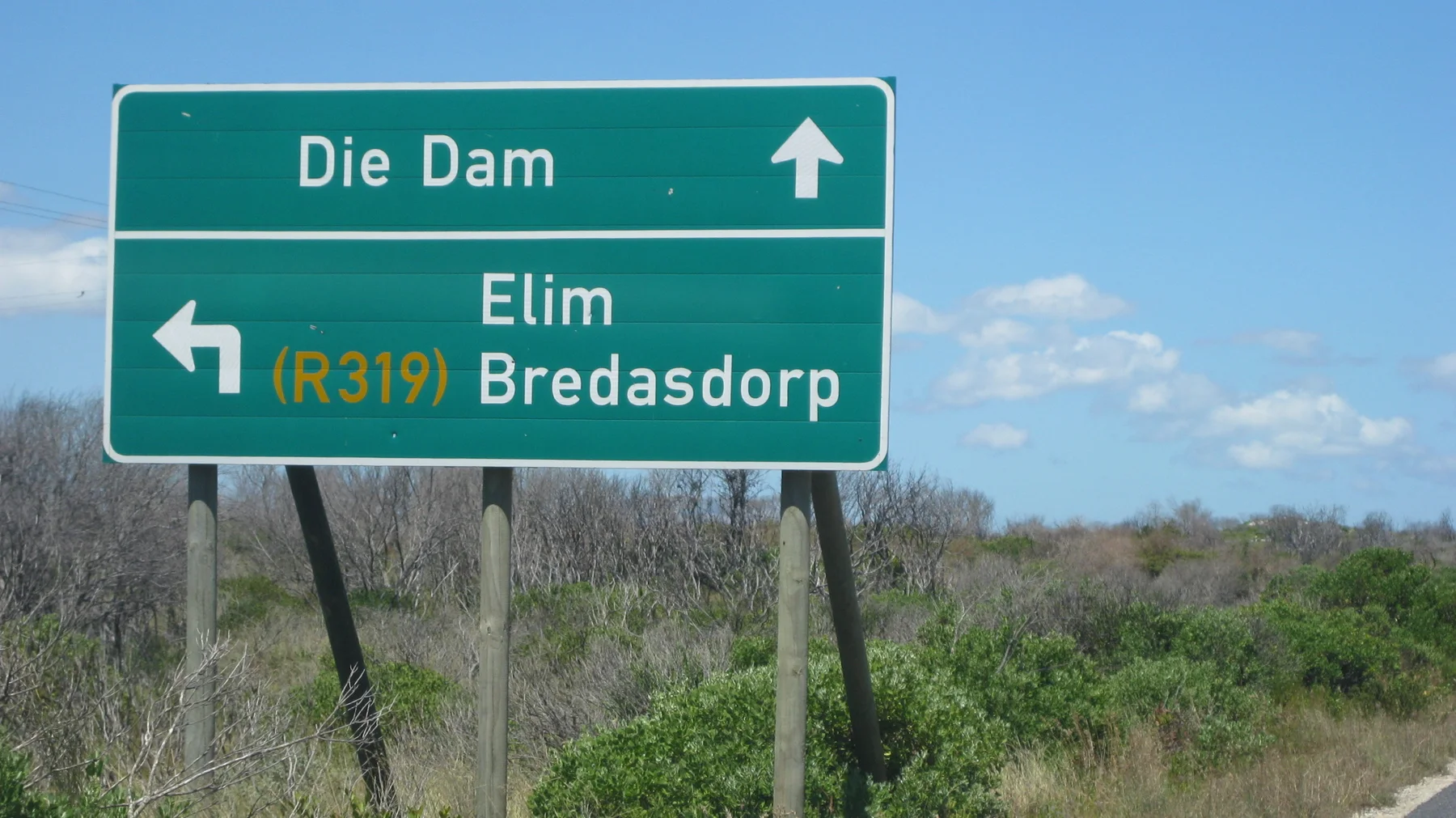 A roadside sign indicates Die Dam ahead and Elim and Bredasdorp left.