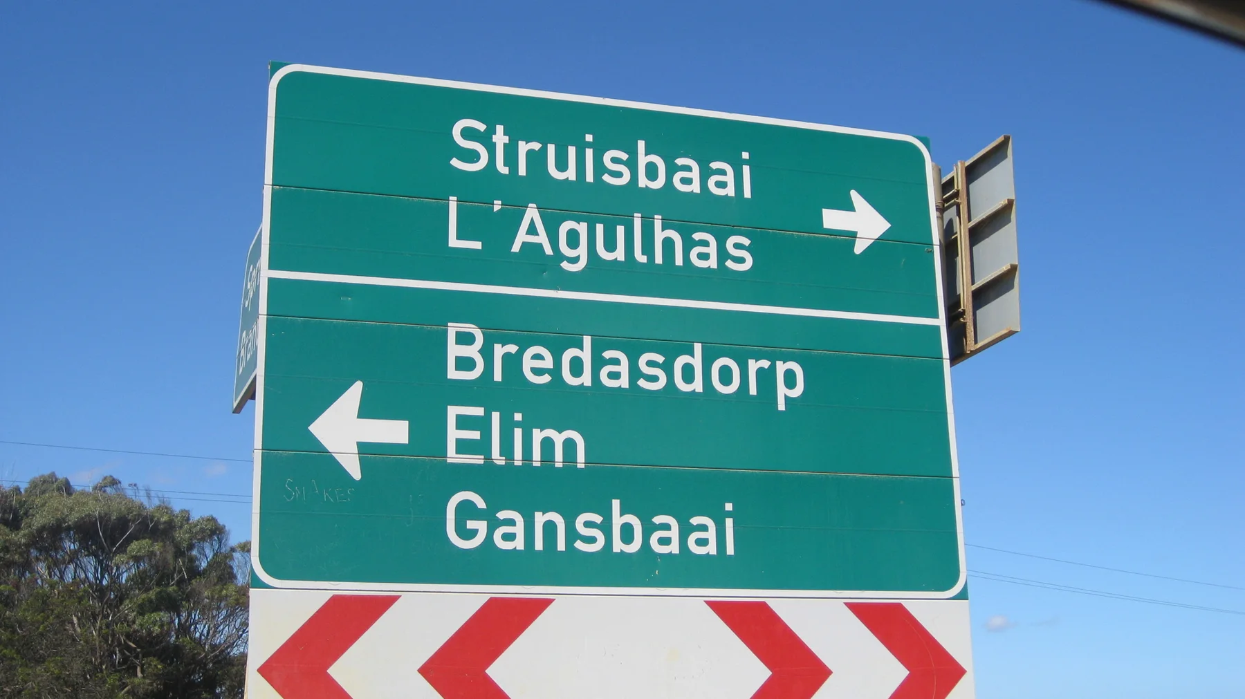 A green sign points toward Struisbaai, L'Agulhas and inland towns.