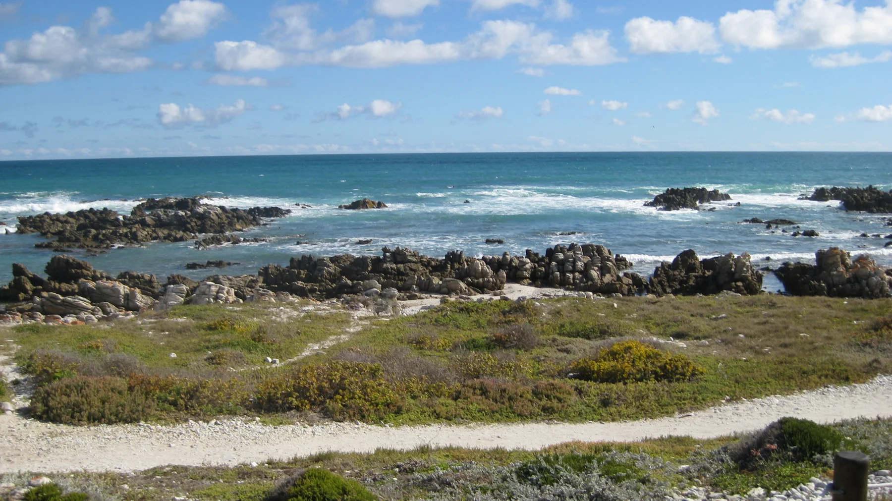 Dark rocks break the surface of turquoise shallows.