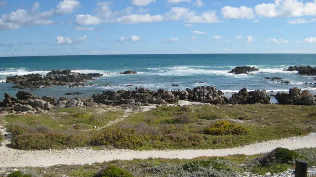 Dark rocks break the surface of turquoise shallows.