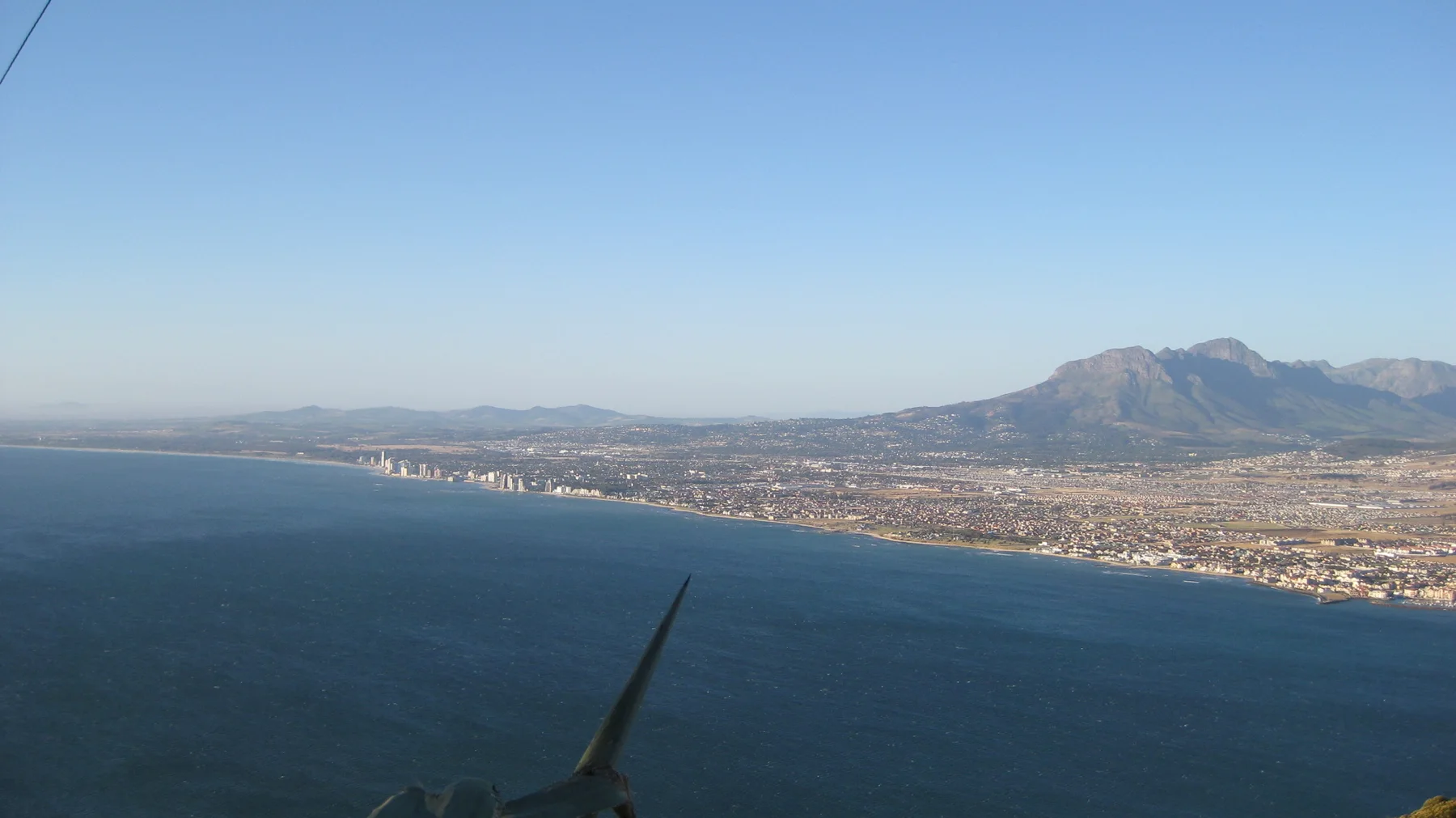 A developed coastline stretches beside deep blue water.