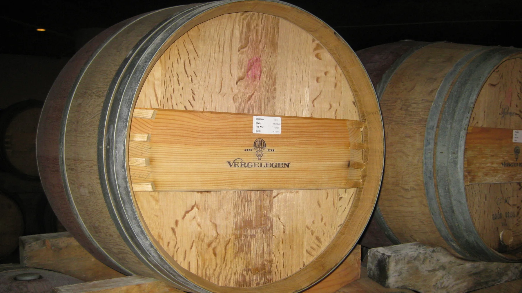 A round wooden barrel face shows grain and dark metal hoops.