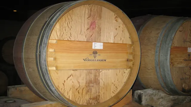 A round wooden barrel face shows grain and dark metal hoops.