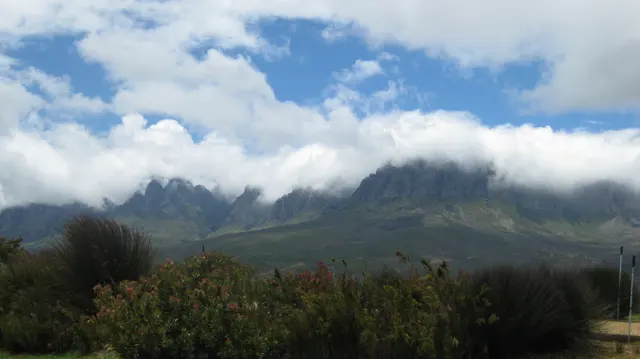 Low clouds gather among jagged mountain peaks.