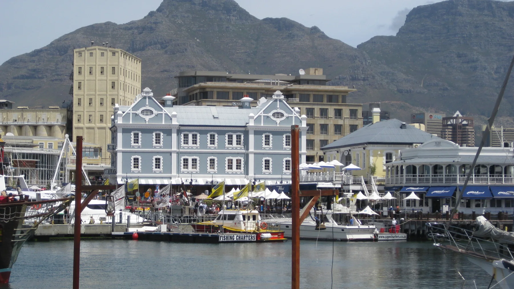 An ornate pale-blue facade stands across calm harbor water.
