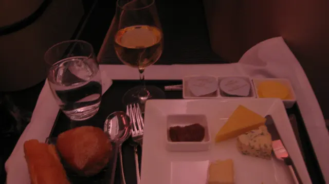 Small plates, bread and glasses sit on a compact meal tray.