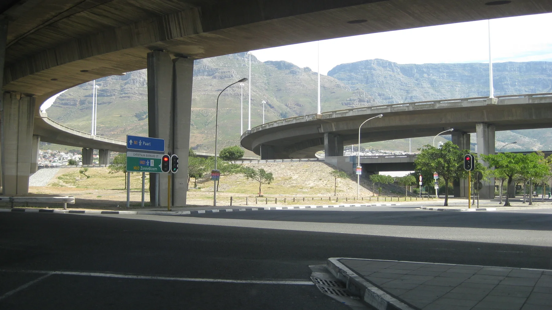 Curving elevated roads cross above a shaded city junction.