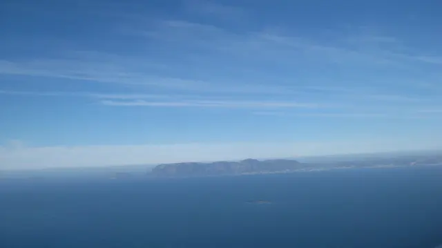 A low distant island appears across deep blue water.